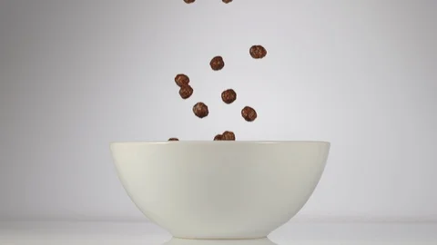 SLOW MOTION: Chocolate balls falling in a white dish on a white background Stock Footage 108959583