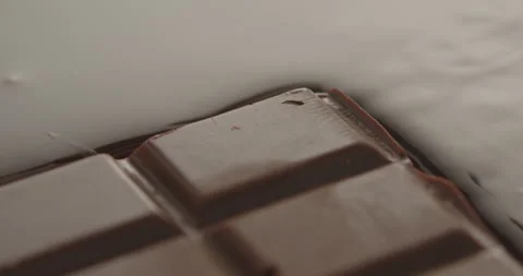 Slow Motion Chocolate Bar Falling into Liquid Chocolate - Rich Dessert Footage Stock Footage 276875152