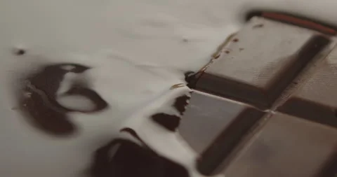 Slow Motion Chocolate Bar Falling into Liquid Chocolate - Rich Dessert Footage Stock Footage 276875161