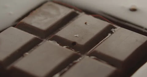 Slow Motion Chocolate Bar Falling into Liquid Chocolate - Rich Dessert Footage Stock Footage 276875174