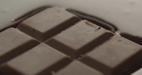 Slow Motion Chocolate Bar Falling into Liquid Chocolate - Rich Dessert Footage Stock Footage 276875205