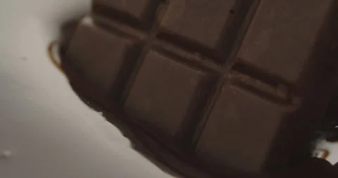 Slow Motion Chocolate Bar Falling into Liquid Chocolate - Rich Dessert Footage Stock Footage 276875274