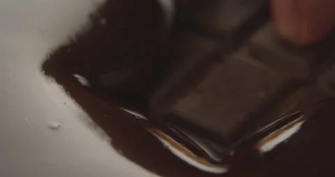Slow Motion Chocolate Bar Falling into Liquid Chocolate - Rich Dessert Footage Stock Footage 276875282