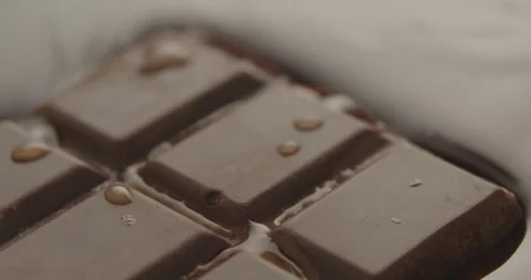 Slow Motion Chocolate Bar Falling into Liquid Chocolate - Rich Dessert Footage Stock Footage 276875307
