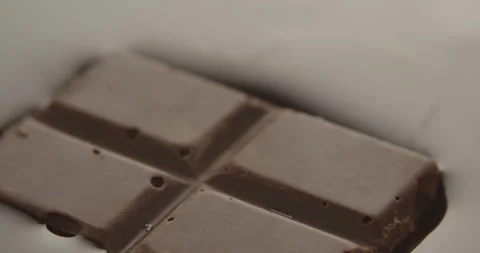 Slow Motion Chocolate Bar Falling into Liquid Chocolate - Rich Dessert Footage Stock Footage 276875339