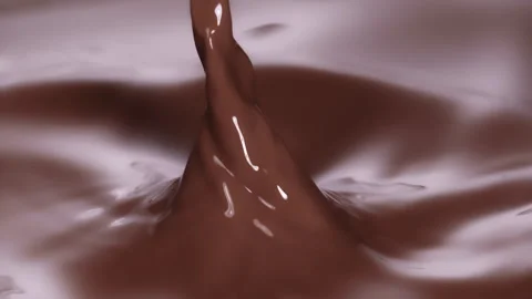 Slow motion: Chocolate piece falling into brown, chocolate liquid. UHD25p Stock Footage 249597870
