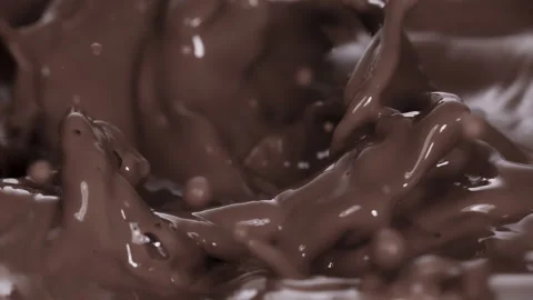 Slow motion: Chocolate pieces falling into chocolate liquid. UHD25p Stock Footage 249596987