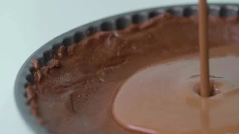 Slow motion chocolate pouring into pie dish Stock Footage 166863257