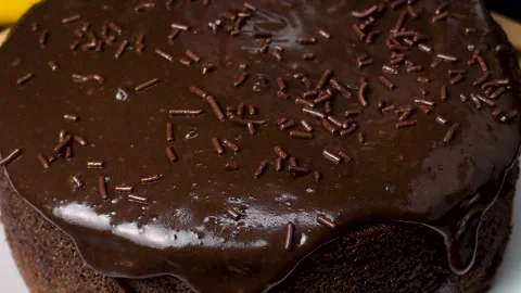 Slow Motion Chocolate Sprinkles Falling on Ganache-Covered Moist Chocolate C Stock Footage 306268321