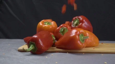 In slow motion chopped pieces fall on a whole bell pepper Vidéo 116505014