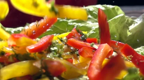 Slow motion chopped vegetables fall on the salad leaves Stock Footage 68672537