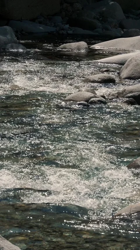 Slow motion of churning white foam on mountain river through narrow channel Stock Footage 346246984