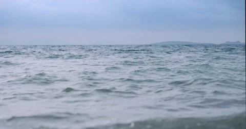 Slow motion cinematic shot of disturbed blue ocean water surface Stock Footage 325606737