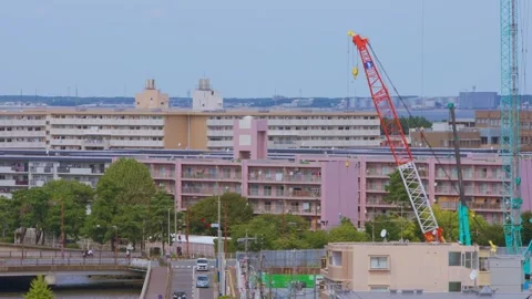 Slow motion city skyline with cranes and buildings under blue morning sky Japan Stock Footage 322181908