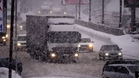 Slow motion City traffic in Snowfall Stock Footage 70791368