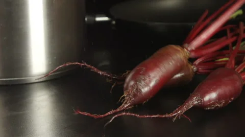 SLOW MOTION: Clean beets fall on a black table on a kitchen Stock Footage 68155812