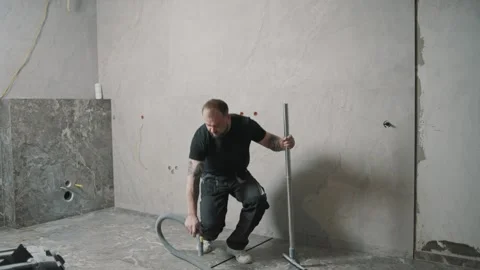 Slow motion cleaning of tile flooring by a man in a construction site Stock Footage 307041997