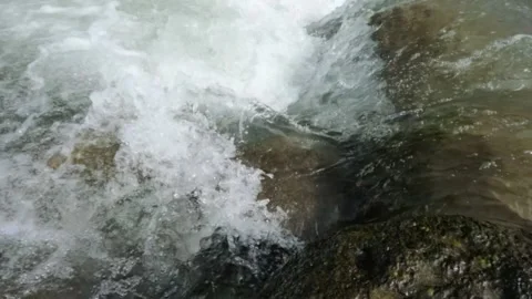Slow motion of a clear flowing mountain river in the rocks of the river Stock Footage 320984812