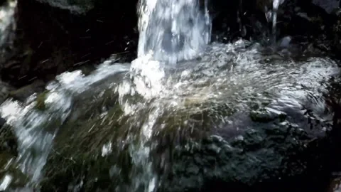 Slow motion of clear flowing water falling through the rocks Stock Footage 292228847