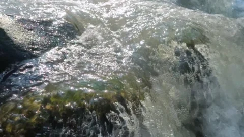 Slow motion of clear mountain river water flowing through rocks Stock Footage 320982381