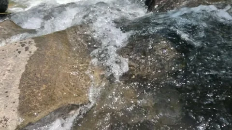 Slow motion of a clear mountain river flowing through a rocky cascade Stock Footage 321264909