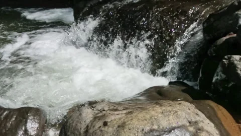 Slow motion of a clear mountain river flowing through a rocky cascade Stock Footage 321265055