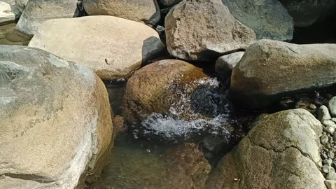 Slow motion clear mountain stream flowing between smooth boulders in natural Stock-Footage 342964860