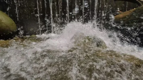 Slow motion of clear river water splashing onto rocks Stock Footage 321845315