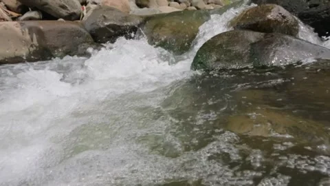 Slow motion of clear rocky mountain river water flow Video stock 320921502