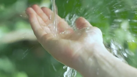 Slow motion of clear water streaming on a human hand 스톡 동영상 74632534