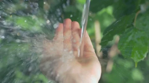 Slow motion of clear water streaming on a human hand Stock Footage 74632610