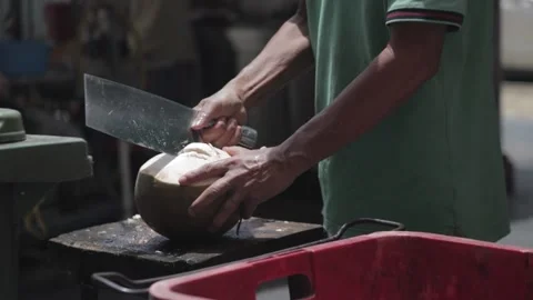 Slow motion clip of a man chopping open a coconut 動画素材 137839095