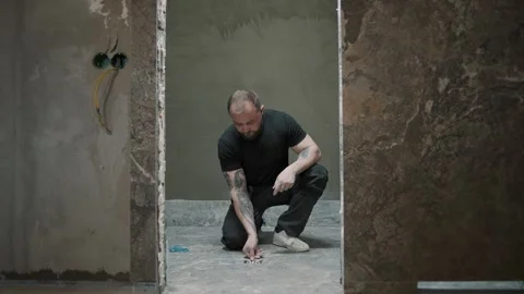 Slow motion clip of a man installing tile in a stylish interior setting Video stock 307041812