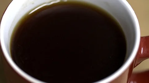 Slow motion clip of milk being poured into a cup of tea Stock Footage 87857680