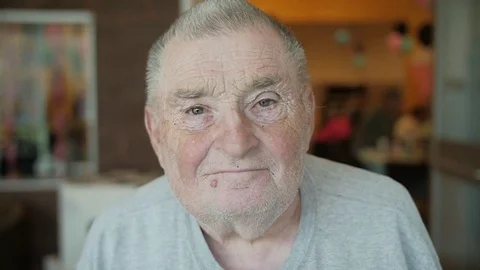 Slow-Motion Clip Of Old White Man Lifting His Head And Smiling At Camera Video stock 76133110
