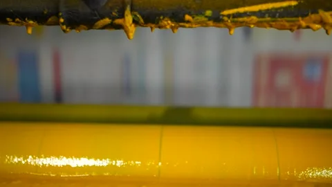 Slow motion clip of rollers of a newspaper printer coloured yellow Stock Footage 155786117