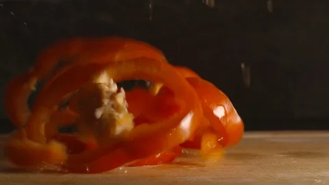Slow motion clip of a sliced red pepper dropping onto a chopping board Stock Footage 87857565