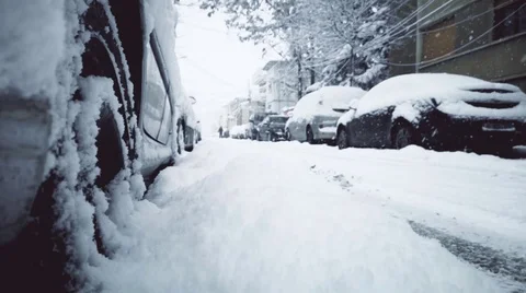 Slow motion clip with snowfall on a street with parked cars 스톡 동영상 102902016