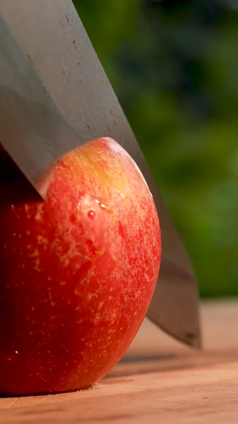 Slow-motion close-up of an apple slice attempt that stops halfway with a sharp Stock Footage 322158596