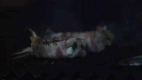 Slow motion close up of bacon wrapped shrimp being grilled in industrial kitchen Stock Footage 204251080