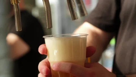Slow motion close up of bartender hands pours beer into a plastic glass. Close Stock Footage 279550962