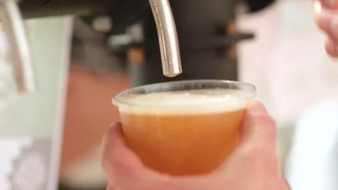 Slow motion close up of bartender hands pours beer into a plastic glass. Close Stock Footage 279550973