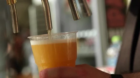 Slow motion close up of bartender hands pours beer into a plastic glass. Close Stock Footage 279551018