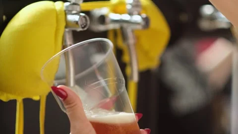 Slow motion close up of bartender hands pours beer into a plastic glass. Close Stock Footage 279551053