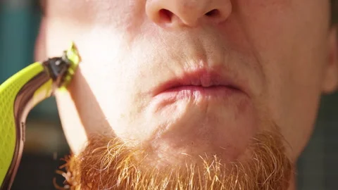 Slow Motion Close Up of a Bearded Man Shaving Facial Hair on His Cheek with an E Stock Footage 342618996