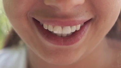 SLOW MOTION CLOSE UP: Beautiful young woman with perfect white teeth starts Video stock 109285343