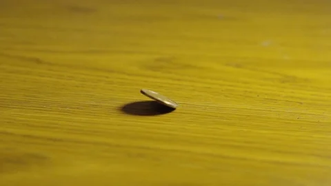 Slow Motion Close Up Canadian Loonie Coin Spinning Circles And Stopping On Stock Footage 106987550