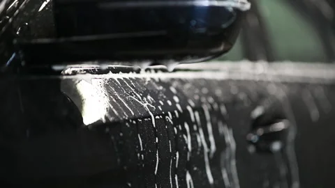 Slow motion close up of car mirror in car wash. Foam drops dripping from a side Stock Footage 146297919