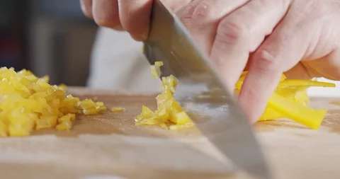 Slow motion close up of a chef knife slicing a yellow bell pepper Stock Footage 125522553