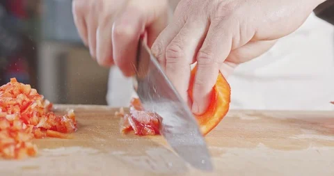 Slow motion close up of a chef knife slicing a Red bell pepper Stock Footage 125524420